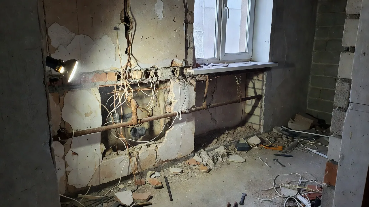 Вскрытая стена со старой трубой и проводкой — непредвиденные работы, из-за которых растёт смета ремонта квартиры